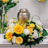 Arrangement de fleurs funéraires sur piédestal pour urne